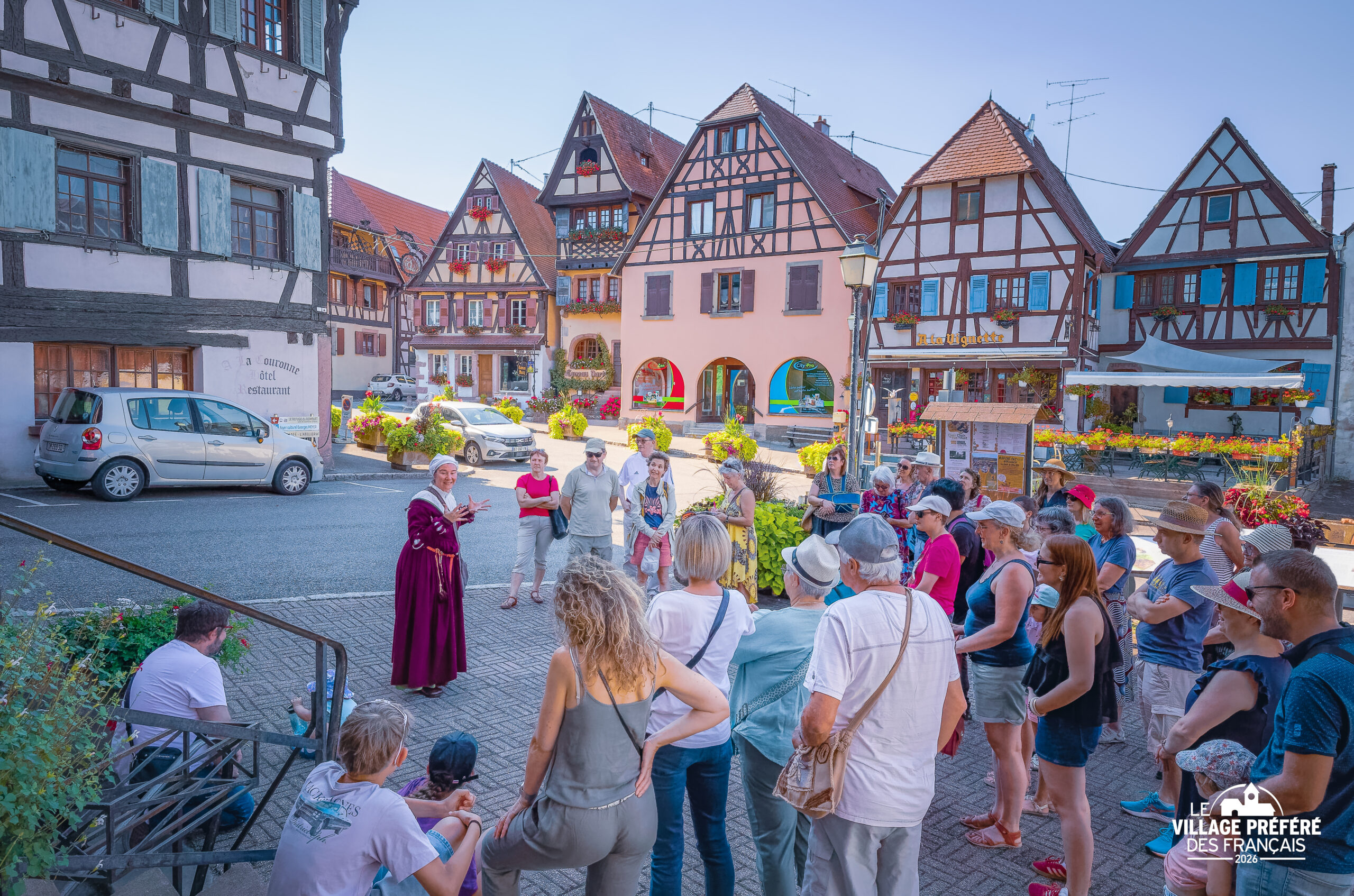 Visite guidée à Dambach-la-Ville : une habitante en costume alsacien raconte l'histoire du village aux visiteurs
